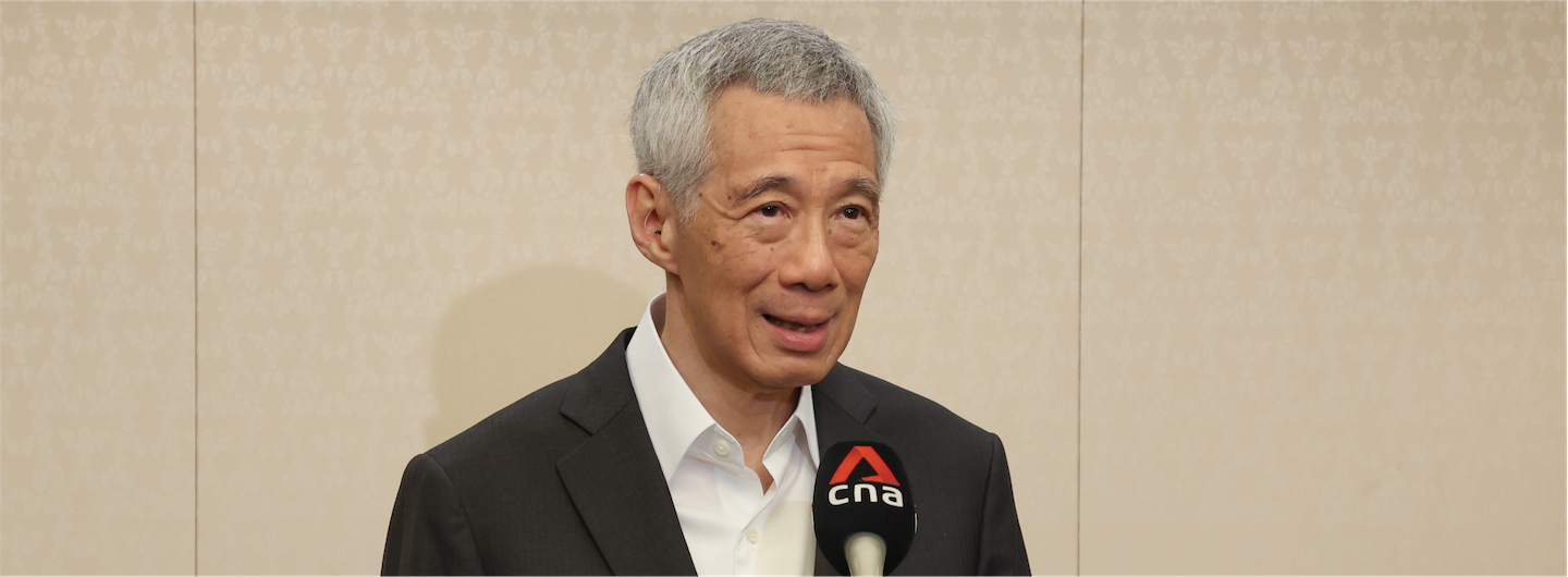 Lee Hsien Loong with a CNA microphone, wearing a suit.
